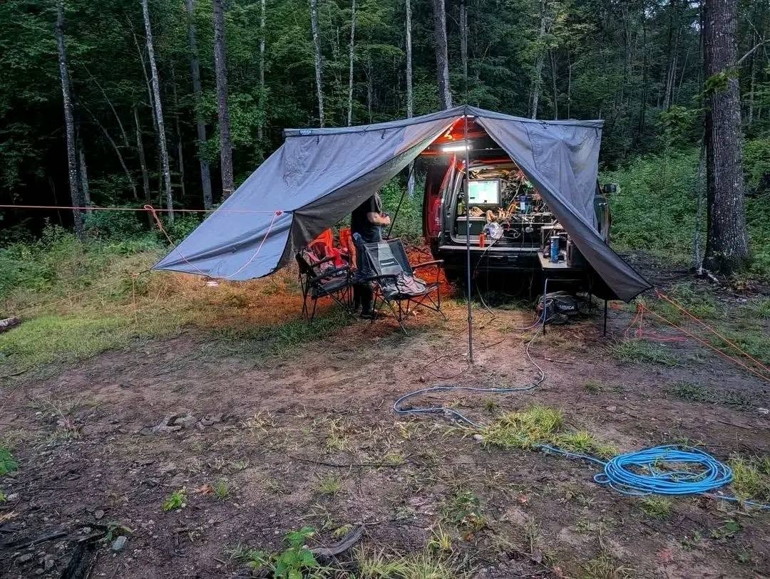 Mobile field base set up under a tarp in the woods